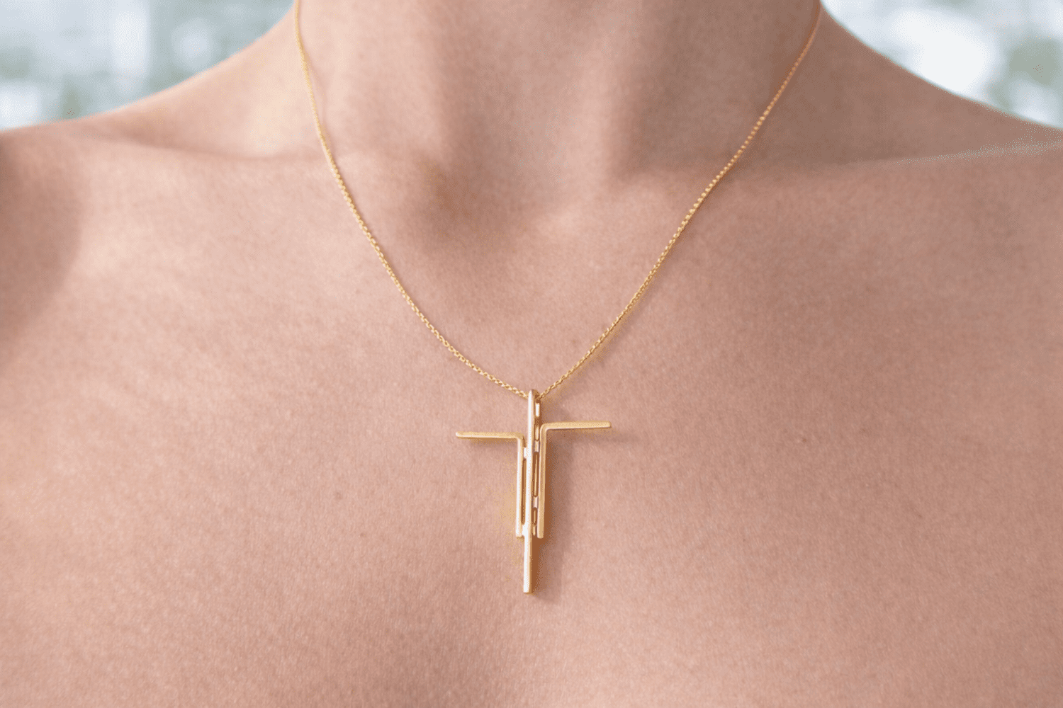 Cruz de cristo com banho de ouro num pescoço de mulher